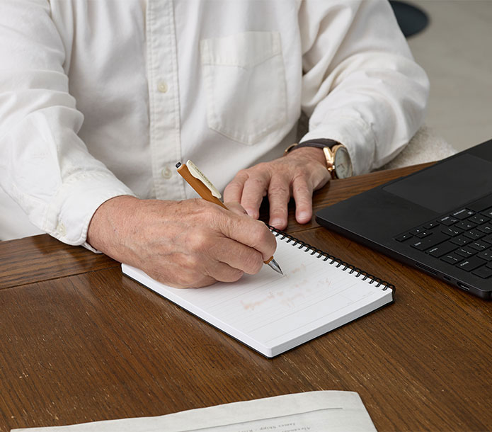 Dr. Richard C. Schwartz writing in a notepad at his desk